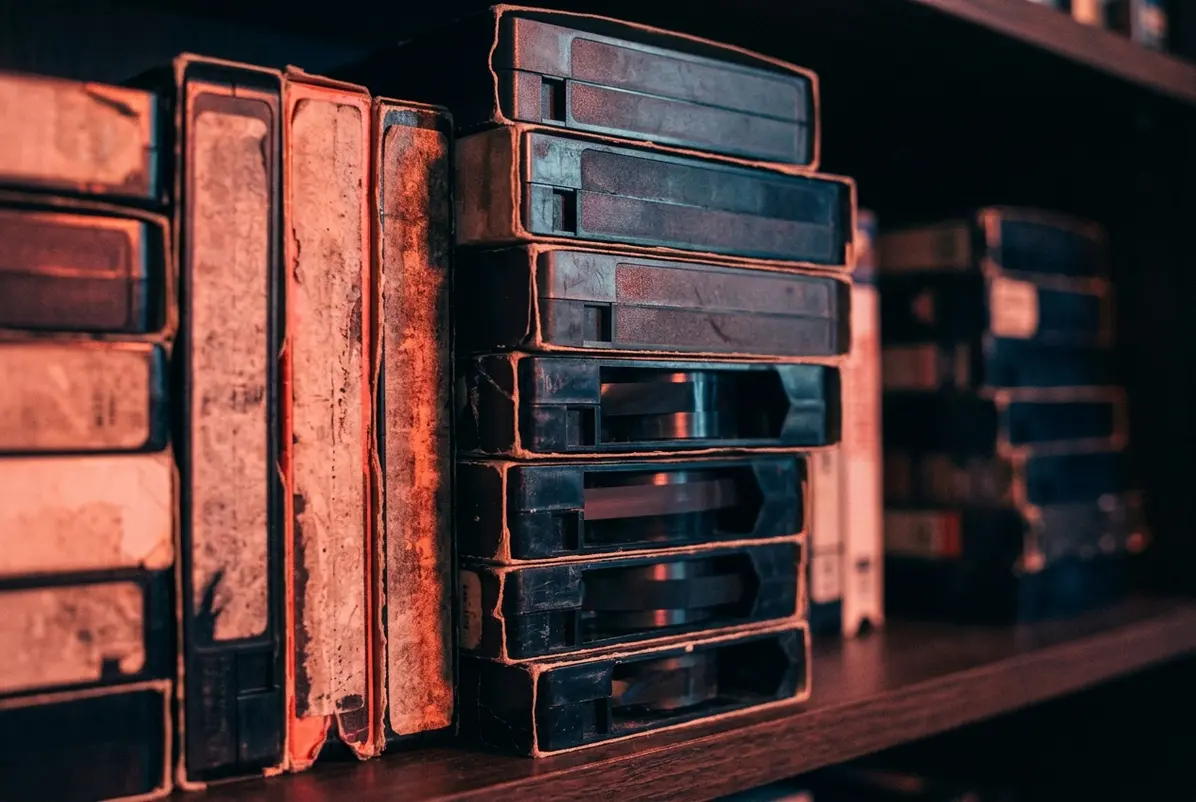 The VHS Comeback Is Selling Permanence, Not the Past 1 Rows of secondhand tape spines, worn but no longer disposable.